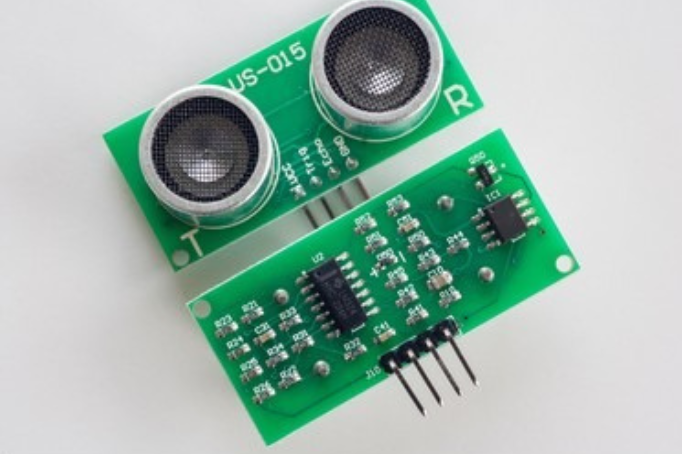 A close-up of a green printed circuit board (PCB) with various electronic components, including a microprocessor, capacitors, and connectors.